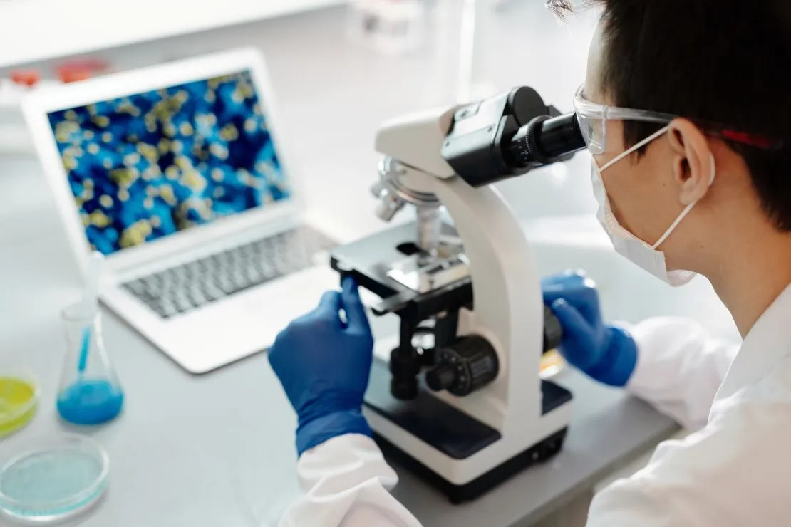 Specialista al microscopio in laboratorio